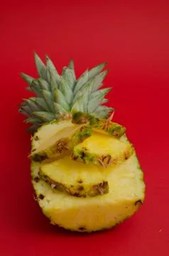 Sliced pineapple fruit on red background Foto stock
