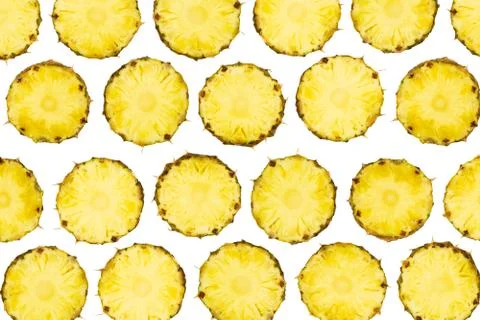 Sliced pineapple pieces lay in pattern on isolated white background Stock Photos