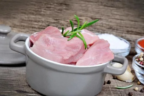 Sliced of pork in a pot on rustic table Stock Photos