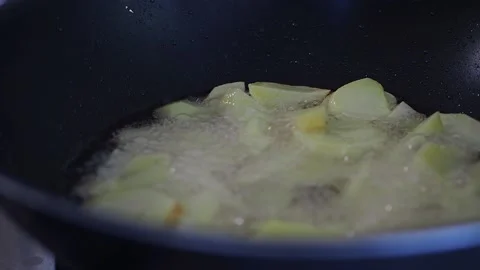 A sliced potato is fried in a pan. Stock Footage 142667396