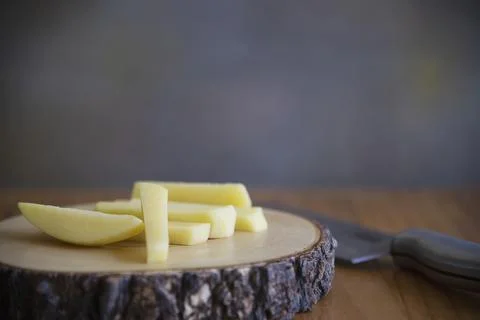 Sliced potato stick ready for making French fries - traditional food preparat Stock Photos