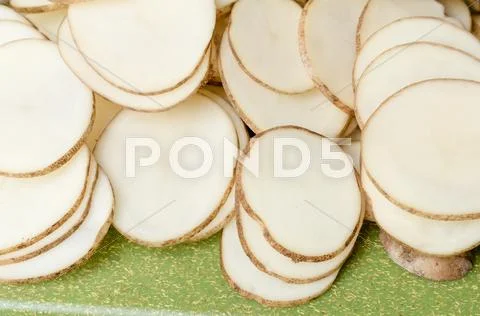 Sliced potatoes on green cutting board Stock Photos