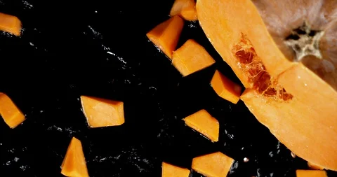 Sliced pumpkin falls to the water with a splash. Stock Footage 130142616