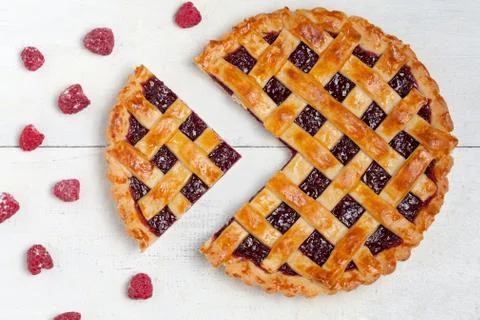 Sliced raspberry pie with fresh raspberries on white table Stock Photos
