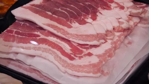 Sliced ​​raw bacon lying one after another in a row. Close-up of raw bacon. 스톡 동영상 302191053