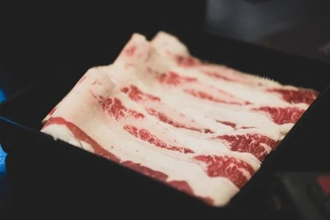 Sliced raw beef place in a row on a black plastic tray Stock Photos