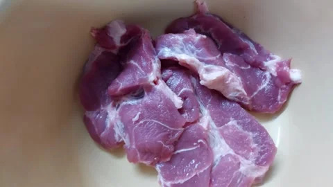 Sliced raw pork neck in a ceramic bowl Vídeos de archivo 334393311
