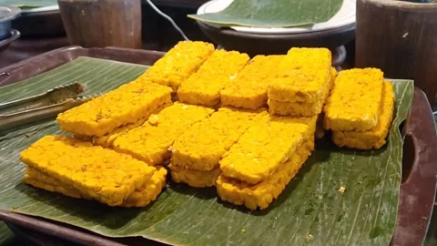 Sliced Raw Yellow Marinated Tempeh on Wooden Board Stock Footage 339377442