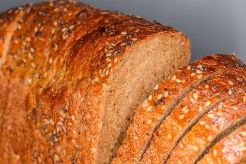 Sliced rectangular loaf of cereal brown bread, fragment close-up Stock Photos