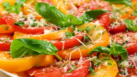 Sliced red and yellow tomatoes are rotating slowly on a plate.  Stock-Footage 341550646