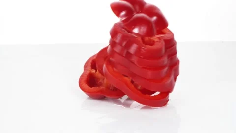 Sliced red bell pepper rings falling in slow motion Stock Footage 147378213