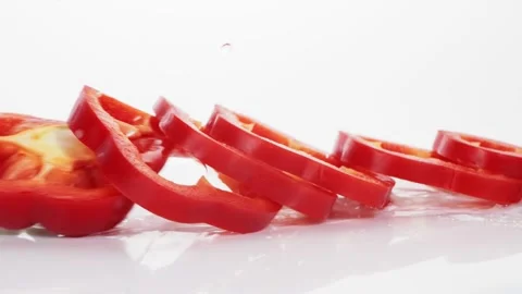 Sliced red bell pepper rings falling in slow motion Stock Footage 147378223