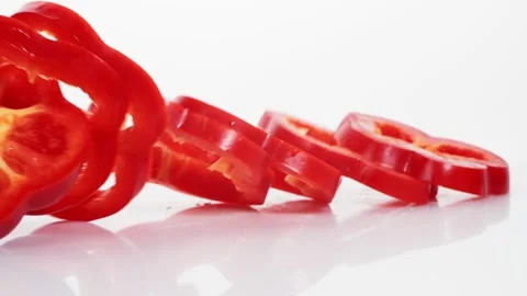 Sliced red bell pepper rings falling in slow motion Stock Footage 147378232
