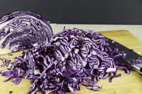 Sliced red cabbage on chopping  board with knife. Stock Photos