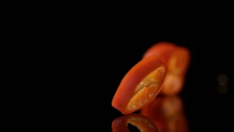 Sliced red chili pepper falling on water surface. Slow Motion. Stock Footage 79478545