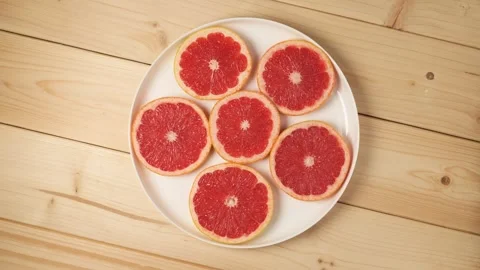 Sliced red grapefruit rotating on a plate Stock Footage 340159863
