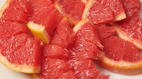 Sliced red grapefruit rotating on white background Stock Footage 342437514