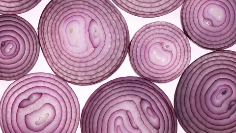 Sliced red onion rings rotating on white in 4K. Vídeos de archivo 87070526