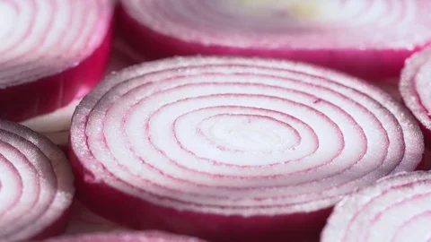Sliced red onion rings rotating on white in 4K. Closeup top view of healthy food Stock Footage 125461608