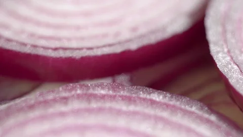 Sliced red onion rings rotating on white in 4K. Closeup top view of healthy food Stock Footage 125461640