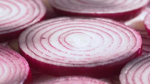 Sliced red onion rings rotating in 4K. Closeup top view of healthy food Stock Footage 125788785