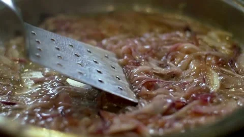 Sliced red onions simmering in a bubbling liquid pan Video stock 333876101