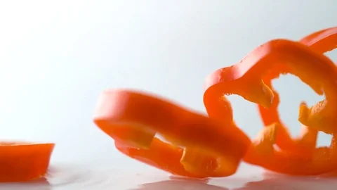 Sliced red pepper falling on water surface. Slow Motion. Stock Footage 79478318