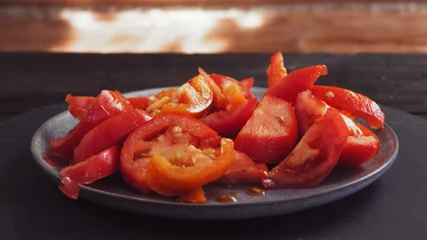 Sliced red tomatoes in a plate rotate in a circle Vidéo 220168642