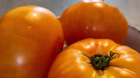 Sliced red tomatoes rotating in deep plate on white Видео 344054200