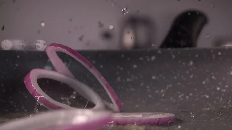Sliced ring onions fall on the frying pan . Slow motion, 240 fps Stockbeeldmateriaal 97908324
