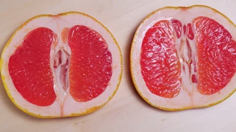 Sliced ripe grapefruit rotation close-up Stock Footage 147081412