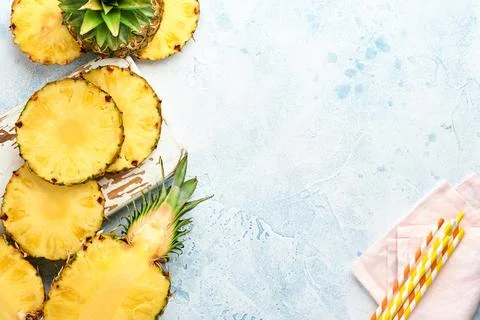 Sliced ripe pineapple on light blue stone background. Tropical fruits. Top vi Stock Photos