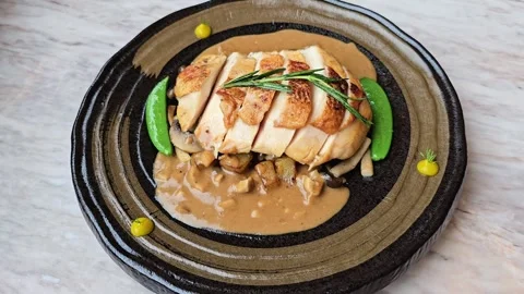 Sliced roasted chicken breast served with brown mushroom sauce. Gourmet dish Stock Footage 310847347
