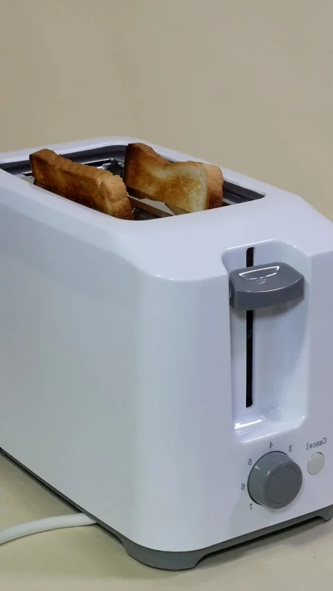 Sliced ​​roasted white bread popping from electric toaster. Stock Footage 297859408