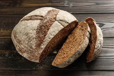 Sliced rustic bread kurpom plan on a wooden surface. Stock Photos