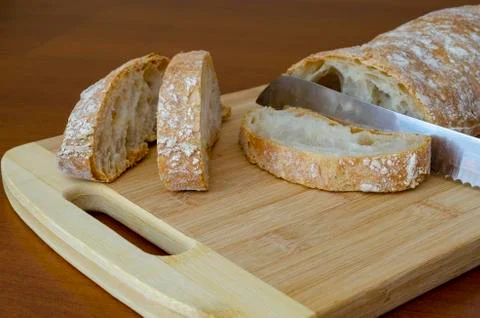 Sliced  rustic bread on wooden table Stock Photos