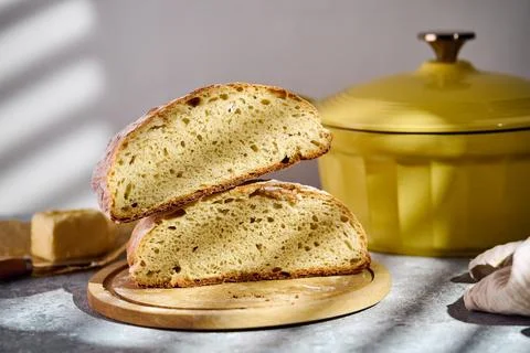 Sliced rustic sourdough bread showing airy crumb texture on wooden board Stock Photos