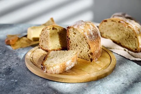Sliced rustic sourdough bread showing airy crumb texture on wooden board Stock Photos