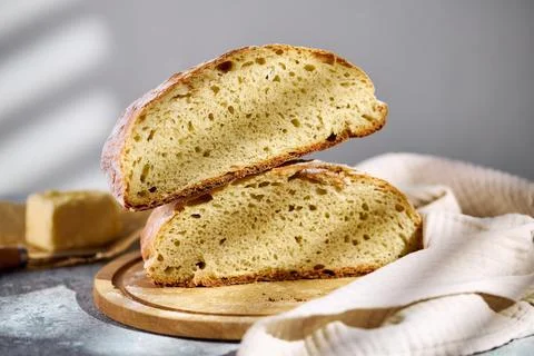 Sliced rustic sourdough bread showing airy crumb texture on wooden board Stock Photos
