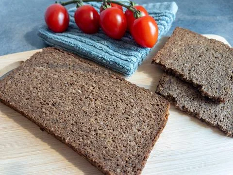 Sliced rye bread and tomatoes on a cutting board close-up Фото