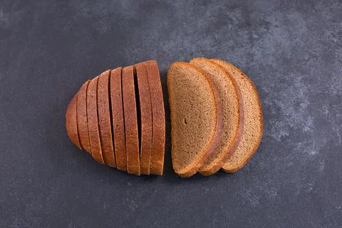 Sliced rye bread on a black table. Stock Photos