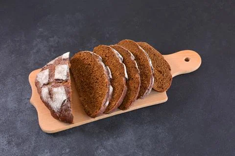 Sliced rye bread on a cuttig Board and a black table. Foto stock