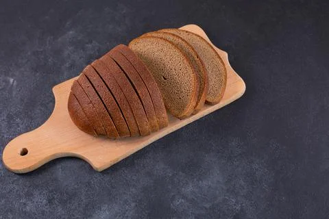 Sliced rye bread on a cuttig Board and a black table. Foto stock