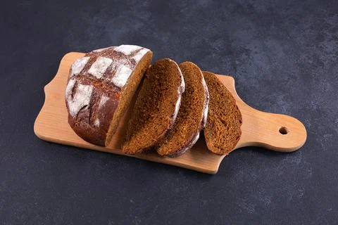 Sliced rye bread on a cuttig Board and a black table. Foto stock