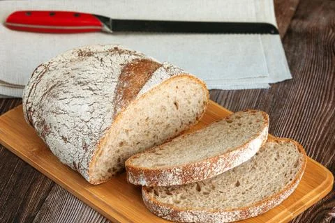 Sliced rye bread with a knife on a cutting board Stock Photos