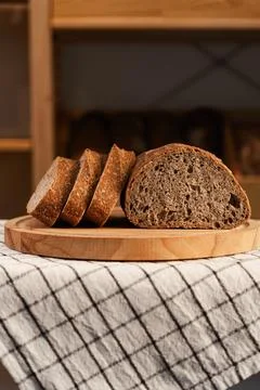 Sliced rye bread loaf on round wooden board Stock Photos