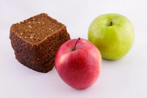 Sliced rye bread on a white background with green and red apples Stock Photos