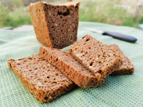 Sliced rye homemade bread square shape on a green towel Stock Photos