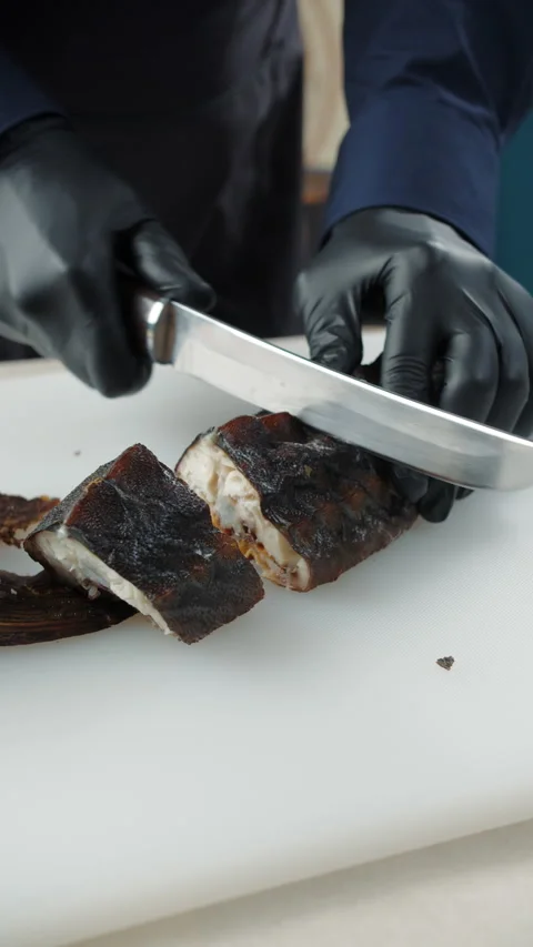 Sliced smoked fish held by chef in gloves Stock Footage 307861642