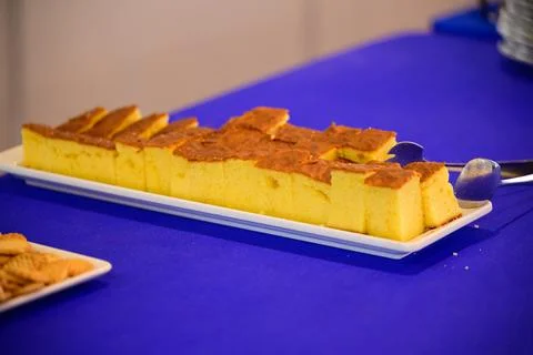 Sliced sponge cake served on a white plate during a catered event buffet on.. Stock-Fotos